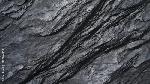 Dark textured stone surface with natural erosion lines resembling geological formations.