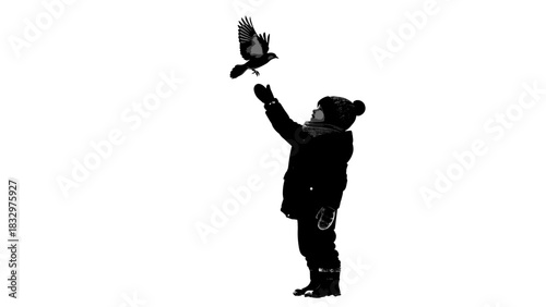 Child reaching out to bird while standing in winter outdoors  