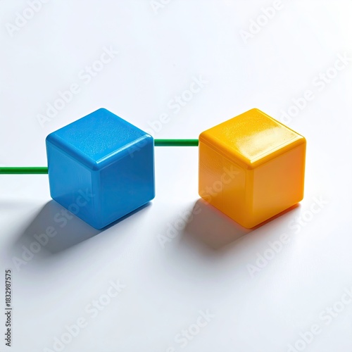 Two brightly colored, square blocks, connected by a thin green line, sit on a white background