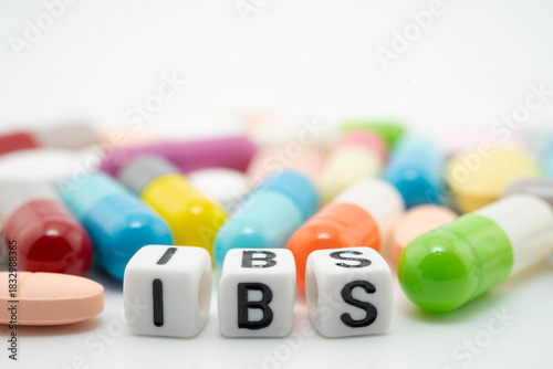 IBS Irritable bowel syndrome word with pills and capsules medical drug.