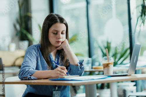 Female Student Studying for Exam in Cloudy University Cafeteria During Quiet Lunch