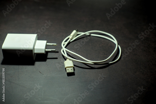 White smartphone charger on dark background.