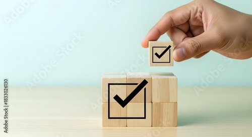 Hand placing checkmark block on stack of blocks