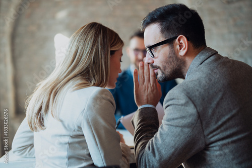 Two businesspeople whisper secretly to each other in the foreground, while a worried client stands anxiously in the background
