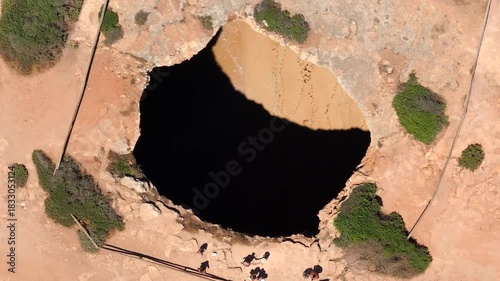 Top down aerial view of the natural skylight opening in the roof of Benagil Cave, Algarve coast, southern Portugal.	