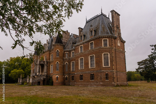Tableau sur toile Empty French château with turrets and mansard roof - weathered brick manor in ov