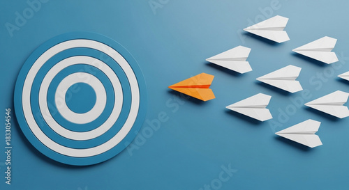 Leadership concept with an orange paper airplane leading a group of white planes towards a target symbolizing innovation strategy and achieving goals on a blue background focus and determination