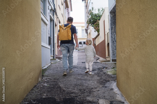 Girl walking with father in narrow streets of Portugal