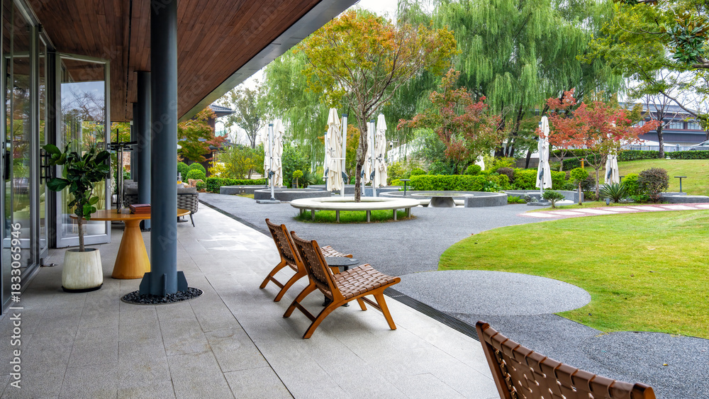 Obraz premium Modern outdoor space with wooden chairs and green plants