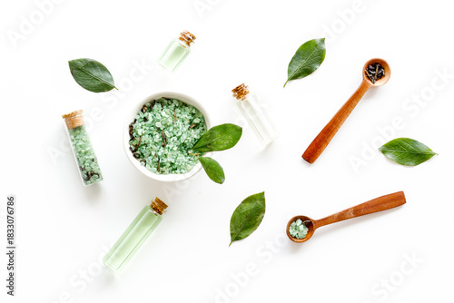 Wallpaper Mural Tea tree essential oil and sea salt near green leaves on white background top view. Organic cosmetics products Torontodigital.ca