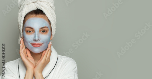 Attractive healthy woman in blue clay cosmetic face mask indoor portrait. Facial treatment and skin care concept