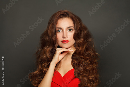 Nice woman with long hair and make-up on black background. Gorgeous woman with curly hairstyle