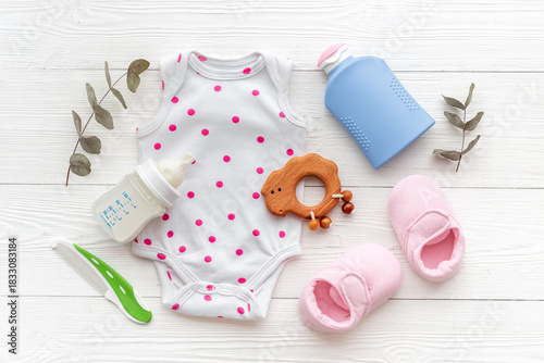 Wallpaper Mural Set of baby hygiene cosmetic products - shampoo and soap with a comb. Eco friendly accessories - bodysuit and wooden toys with bottle of milk on white wooden background, top view Torontodigital.ca