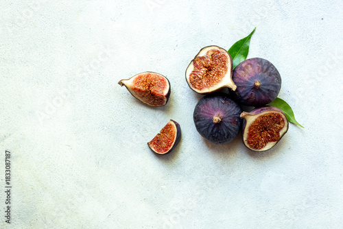 Wallpaper Mural Purple ripe figs fruit and slices with green leaves top view on a stone background Torontodigital.ca