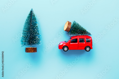 Wallpaper Mural Red toy car carrying Christmas tree. Festive New Year decoration and Christmas background Torontodigital.ca