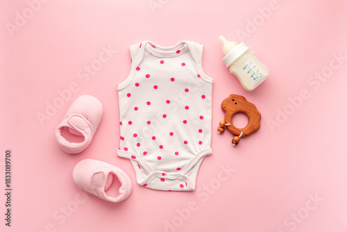 Wallpaper Mural Baby bodysuit with wooden teethers and bottle of milk on pastel pink background, top view Torontodigital.ca