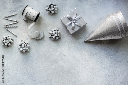 Wallpaper Mural Holiday festive party flat lay with silver carnaval caps and cake candles, top view. Gift box and streamers on gray stone background Torontodigital.ca