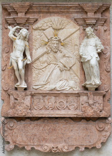 SALZBURG, AUSTIRA - SEPTEMBER 8 2025: The stone relief of Jesus with the cross on exterior wall of the chapel Margarethenkapelle in the St. Peter Abtei cemetery by unknown artist.