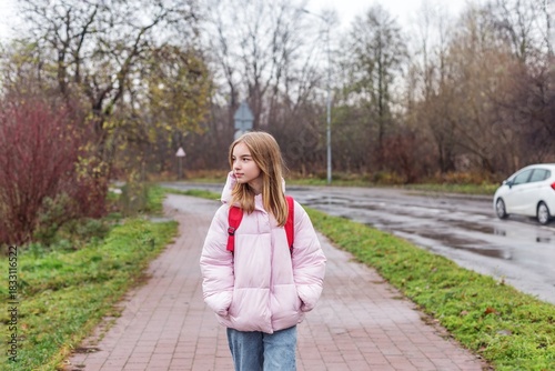 Child walking to school on wet autumn day. Back to school.