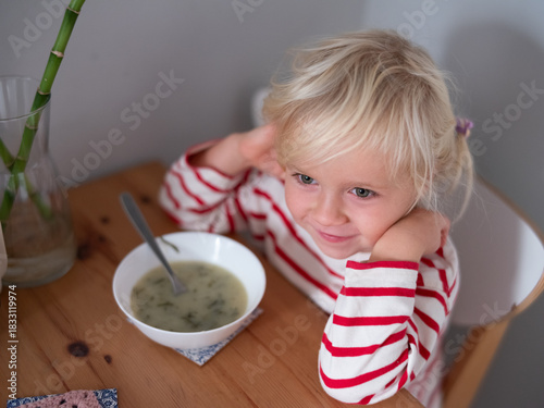 caucasian girl enjoying eating soup