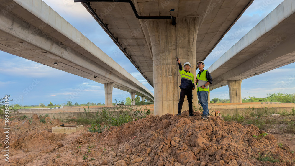 Obraz premium Construction workers assessing infrastructure urban site photographic capture outdoor setting ground-level perspective engineering insights