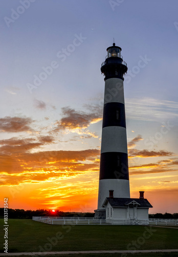 Near Nags Head in Cape Hatteras National Seashore, the historic Bodie Island Lighthouse stands against a sunrise sky over the North Carolina Outer Banks.