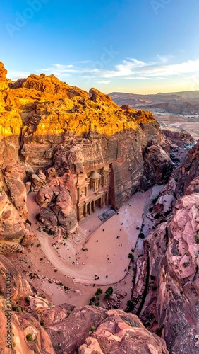 Carved building in sandstone canyon, bathed in golden light, viewed from above