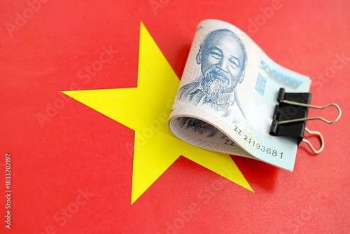 Vietnamese dong currency money bills lies on flag close up. The concept of business and investment