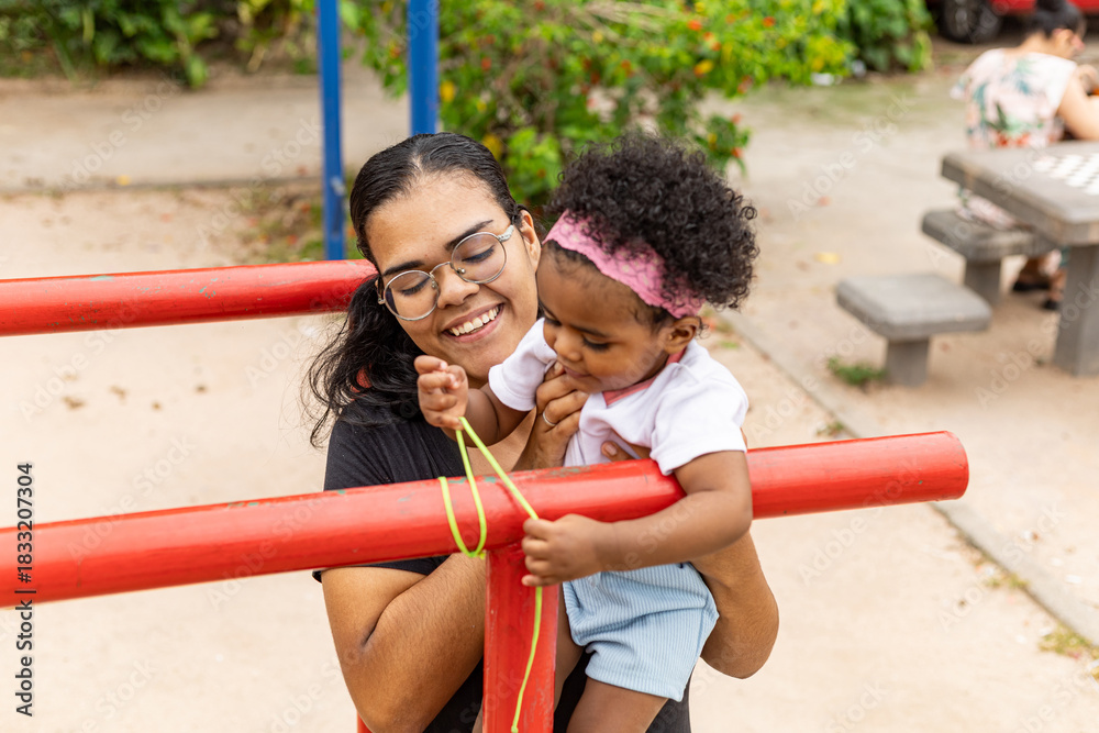 Obraz premium Young Latina Brazilian mother playing in the park with her black daughter. Rio de Janeiro, Brazil.