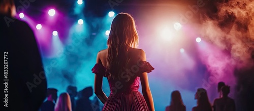 Back View of Woman in Dress at Concert with Stage Lights