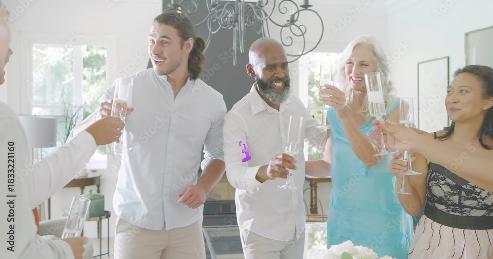 Fototapeta premium Standing friends in smart clothes holding champagne flutes and toasting at home with centerpiece