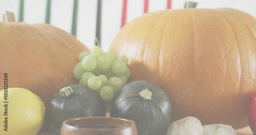 Naklejka premium Displaying autumn produce sitting on tabletop, showing pumpkins, grapes, squashes, lemon, garlic