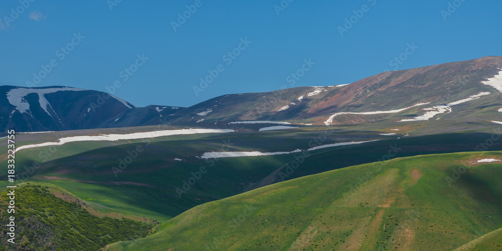 Obraz premium Picturesque hills with remnants of snow on the high-mountain Asy plateau in the Almaty region of southeastern Kazakhstan on a spring morning