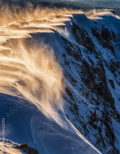 Majestic Snowy Ridge with Wind Blowing Snow at Golden Hour