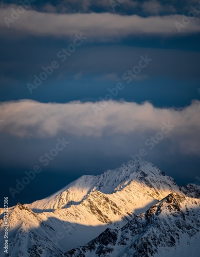Majestic Snow-Capped Mountain Peaks Under Dramatic Cloudy Sky