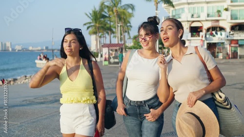 Young women friends walking happily on the boardwalk, enjoying their summer tourism in mexico
