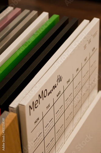 A display of ceramic tile samples in various neutral tones arranged in a showroom. The collection includes stone-texture and matte-finish tiles, creating a professional interior design workspace setti