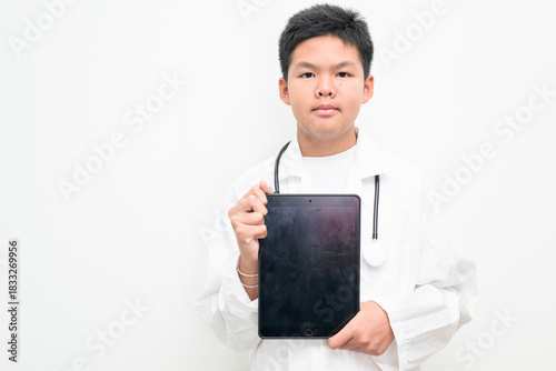 Young Asian Boy Dressed as Doctor with Stethoscope Using Digital Tablet Computer