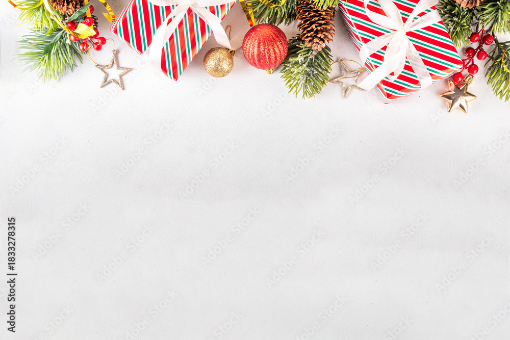 Fototapeta premium White background with Christmas and New Year festive border contains gift boxes, Christmas fir tree branches, decorations and holiday baubles