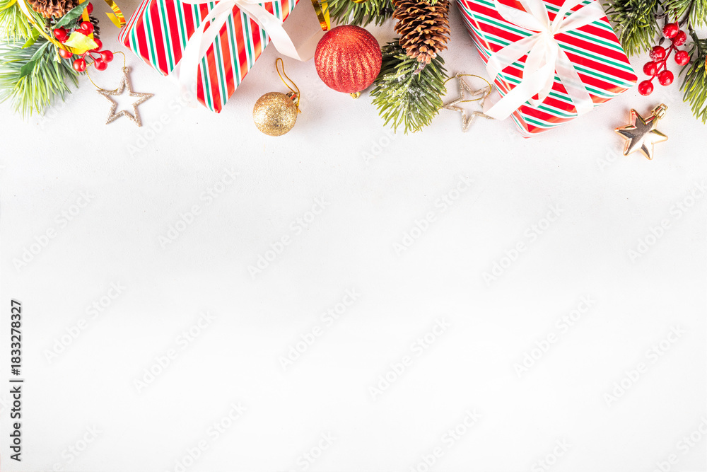 Obraz premium White background with Christmas and New Year festive border contains gift boxes, Christmas fir tree branches, decorations and holiday baubles