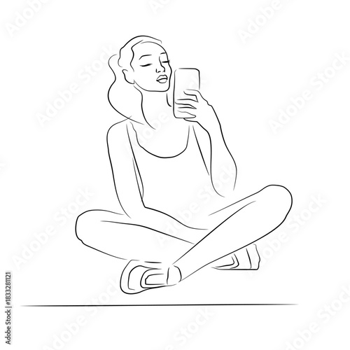 A young woman takes a selfie while sitting on a yoga mat. Relaxation. The female silhouette is drawn with a brush. Sitting pose.