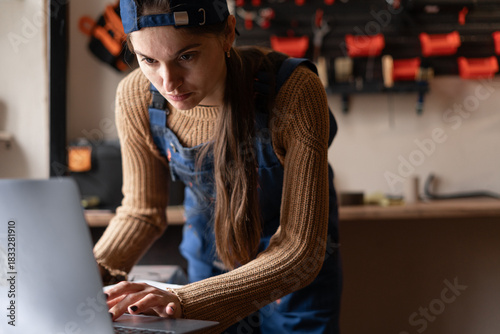 Female craft workshop owner using laptop for online booking and purchasing supplies for small business