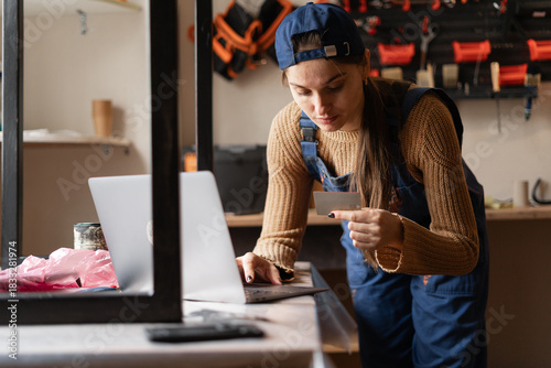 Fotografie Female craft shop owner using laptop and credit card for secure online purchases