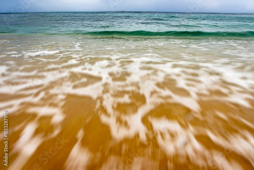 Fototapeta Naklejka Na Ścianę i Meble -  Intentionaly blurred water and sea foam at a beach blurred water and sea foam at a beach