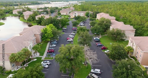 Aerial view of cars parked at suburban apartment complex in Florida, showing family condominiums as part of U.S. housing development.