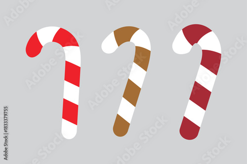 Three colorful candy canes in red brown and white are displayed against a neutral grey background