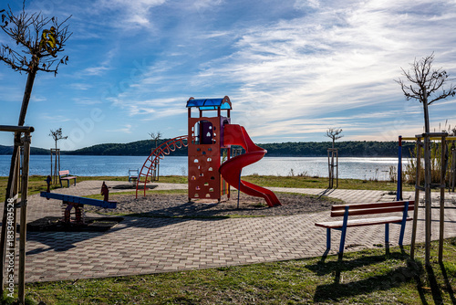 Fototapeta Naklejka Na Ścianę i Meble -  children's playground by the sea, red color, rab, croatia, mediterranean, clear, few clouds