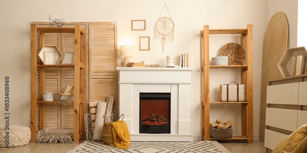 Fototapeta premium Interior of cozy living room with fireplace, shelving unit and dresser