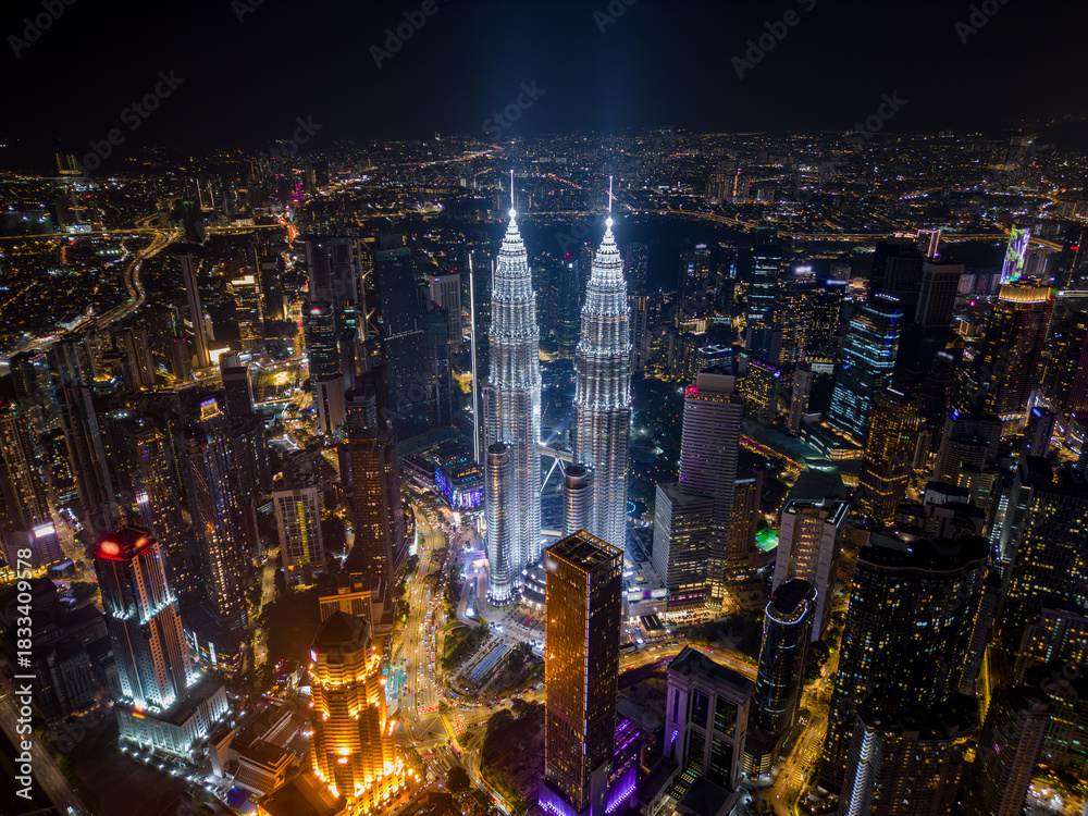 Obraz premium Aerial drone view of Kuala Lumpur downtown with illuminated skyscrapers and the city skyline at night, Malaysia.