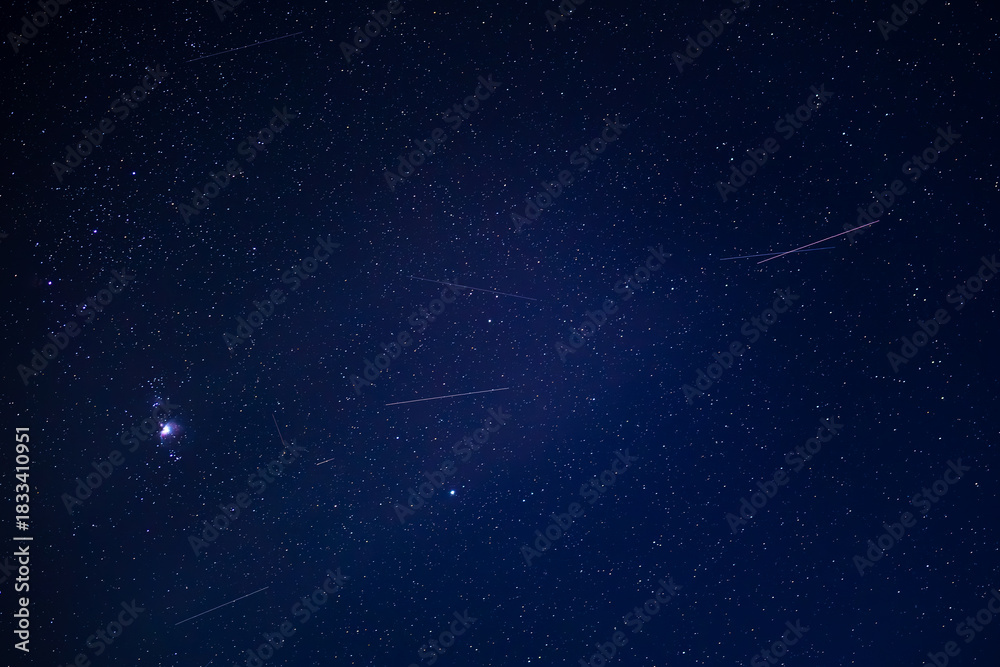 Obraz premium Starry night sky with meteor shower and orion constellation